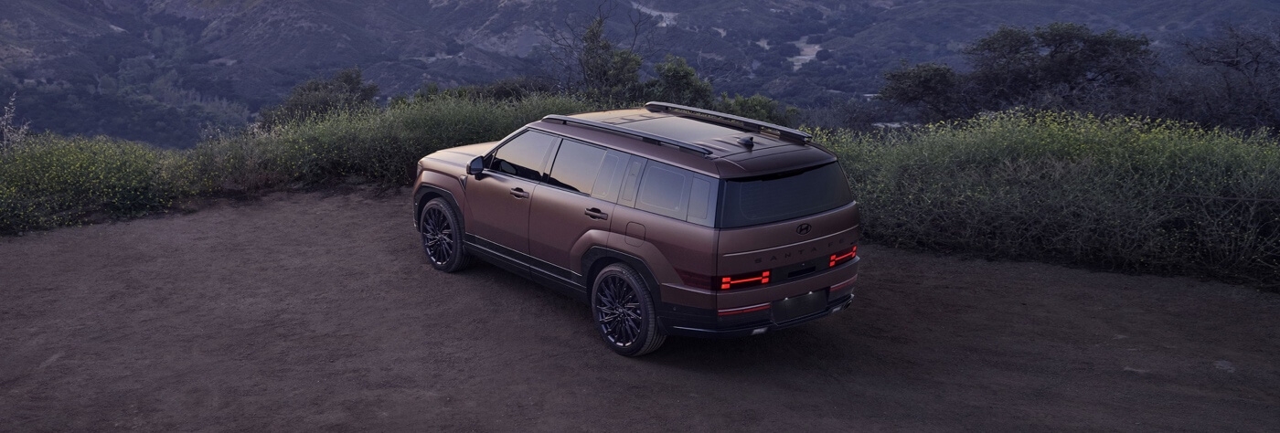 Vue 3/4 arrière du Hyundai Santa Fe 2026 garé sur une montagne.