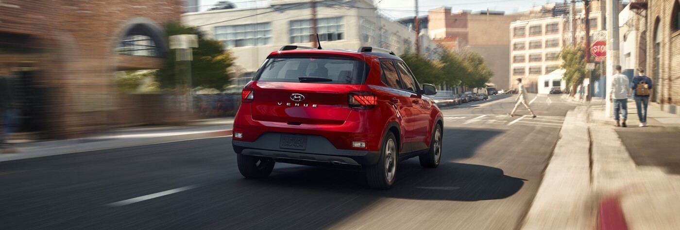 Vue 3/4 arrière du Hyundai Venue 2026 roulant en ville.