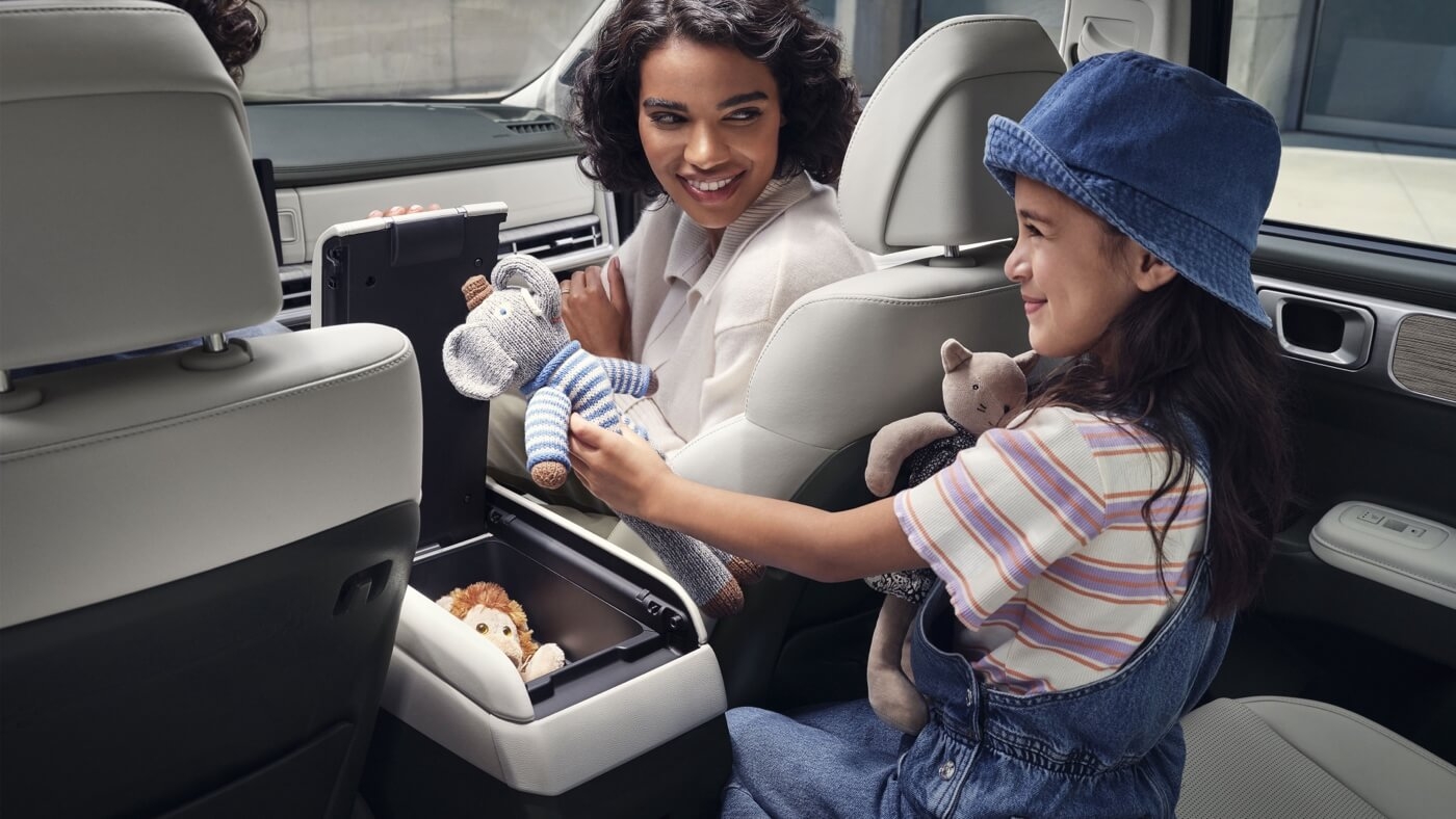 Mère et sa fille insérant des poupées dans la console centrale du Hyundai Santa Fe 2026.