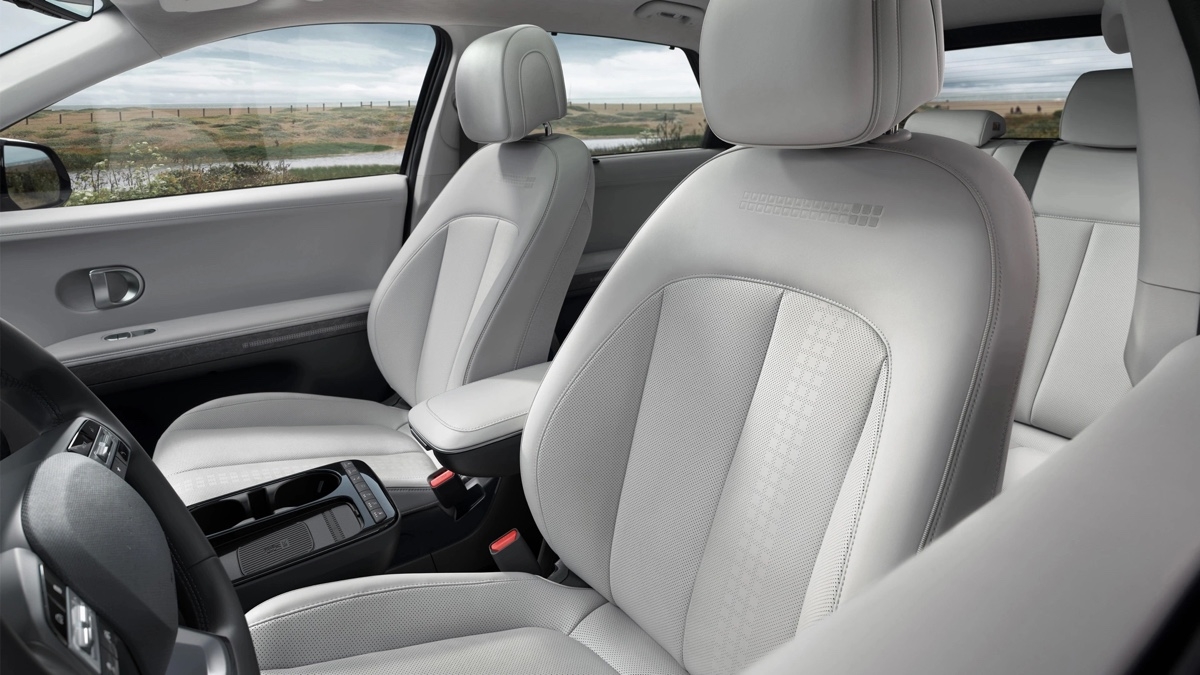 Intérieur du Hyundai IONIQ 5 2025 mettant en valeur les sièges en tissu clair et l’espace avant spacieux.